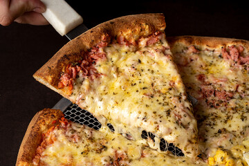Piece of mozzarella cheese pizza and ham