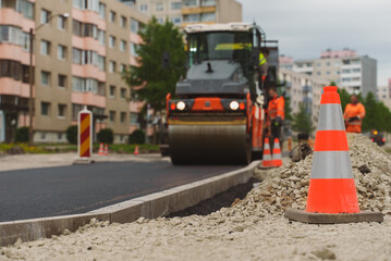 Road reconstruction. Heavy vibration road roller stacking hot asphalt.