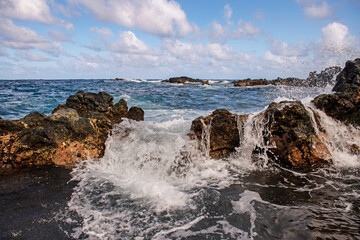 Fototapeta na wymiar Coastal landscape with blue sea and beautiful cliffs. Stone rocks on coast in blue water.