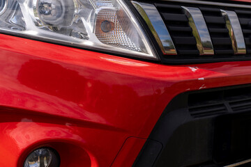 Red car with damaged paint and scratches