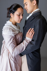 A Regency couple in love in a passionate embrace against a studio backdrop