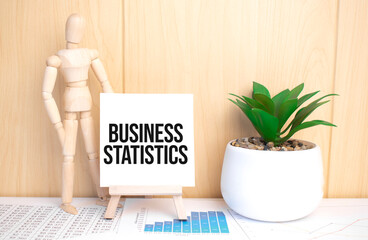 text business statistics on easel with office tools and paper.Top view.