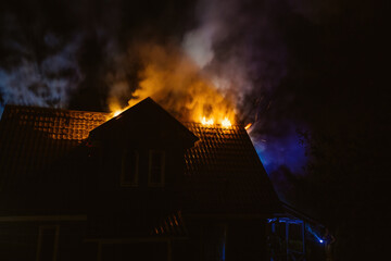 Wooden rural house is burning in fire at night
