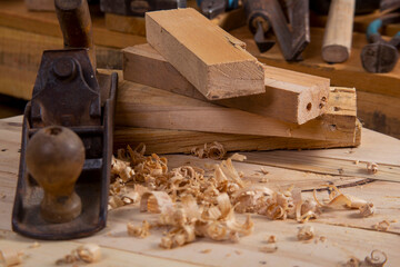 Chisel and antique wood planer with wood shavings