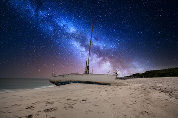 Milky way in the night sky over a shipwreck off the coast of Clam Pass - obrazy, fototapety, plakaty