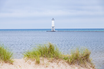 Fototapeta na wymiar Beach grass and dunes at Lake Michigan with Frankfort North breakwater lighthouse in background