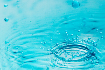 Coroa de gota de liquido colorido caindo sobre uma superfície lisa.