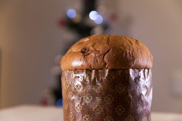 Panettone with blurry Christmas lights blinking in the background. Panettone concept. Christmas concept.
