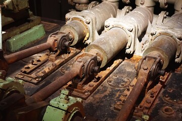 Heavy industrial hydraulic pistons with rust and dim lighting steampunk background