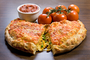 Fogazza tipica comida italiana, aberta mostrando o recheio de frango, queijos, e legumes. em fundo de mesa.