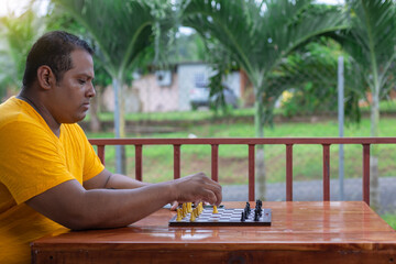 Hispanic man playing chess at the table