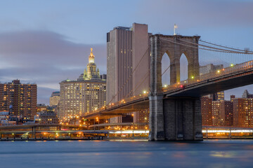Obraz na płótnie Canvas Brooklyn Bridge spanning the East River from Brooklyn into New York City at sundown