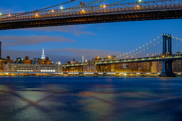 Fototapeta na wymiar The Brooklyn Bridge and the Manhattan bridge spanning the East River from Brooklyn into Lower Manhattan and the financial district of New York City