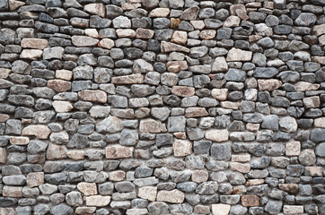 Stone wall texture background. Beige gray stones of different shapes