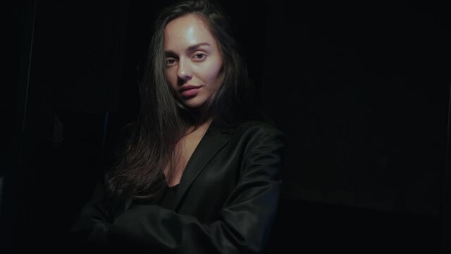 portrait video on a black background of a brunette