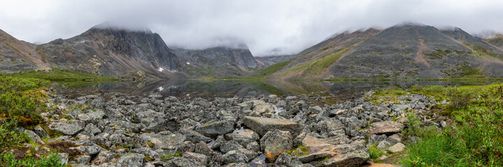 Mountain peaks of Tombstone Territorial Park in northern Canada, during summer time with cloudy, foggy, misty weather and amazing, huge landscape, taken from Grizzly Lake.