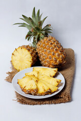 Whole pineapple isolated on a bright background. Close-up view of fresh and delicious pineapple. Overripe pineapples that begin to rot will release a sweet, honey-like liquid. Focus blur. Pineapple mo