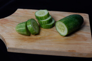 Fresh cucumber isolated on black background. Cucumber which has the scientific name Cucumis sativus L is a fruit that is often eaten as fresh vegetables or as pickles. Cucumber mockup. Focus blur.