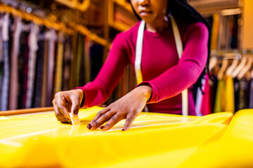 tanzanian woman with snake print turban over hear working in fabrics shop