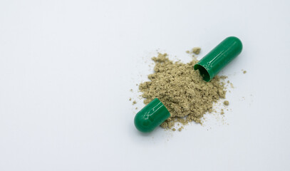 Andrographis paniculata capsules and powder on white background. Andrographis paniculata it is a medicinal plant used in remedies of Thai traditional medicine for decades.