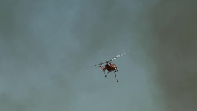 Big fire at Varimbombi, Athens, Greece, August 03, 2021. Ericsson firefighting helicopter attempting through black smoke 120fps