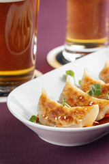 Closeup on japanese gedza dumplings with sauce and beer