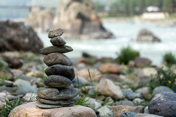 Pyramid of round gray stones on the bank of a mountain river. Zen and harmony concept.Stone tower