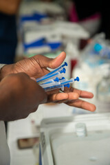 colored man's hands, with syringes for covid 19
