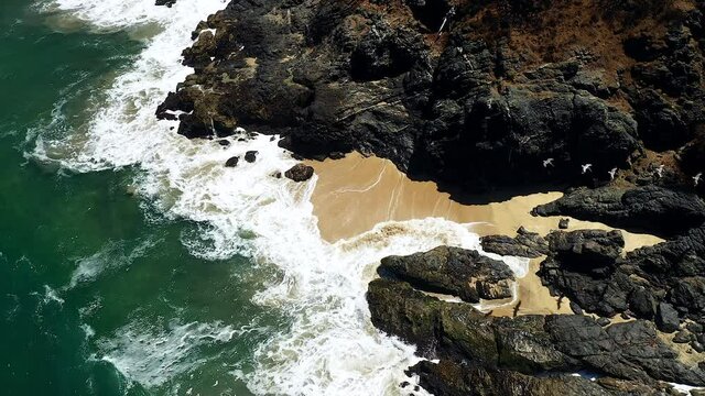 Flock Of Birds Flying Under The Large Beach Rocks On The Seashore Of Playa San Pancho In  San Francisco, Nayarit, Mexico. aerial