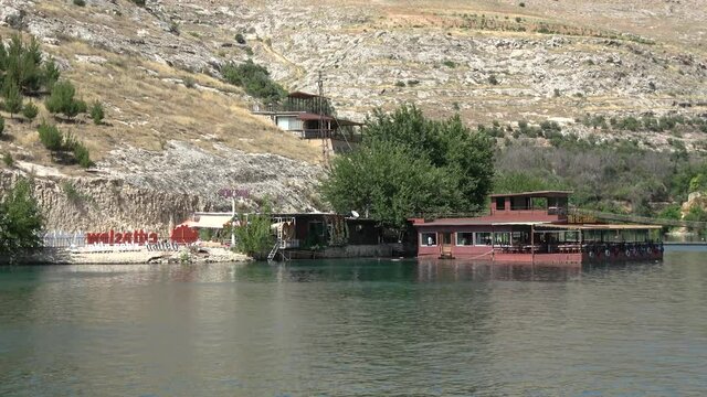 Halfeti, Sanliurfa, Turkey - 14th of June 2021: 4K Passing hithe restaurant approaching to the old Halfeti town
