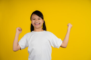 Yes. Happy little asian girl shaking fists, making winner gesture.