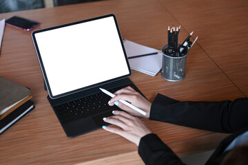 Businesswoman holding stylus pen and working with computer tablet.