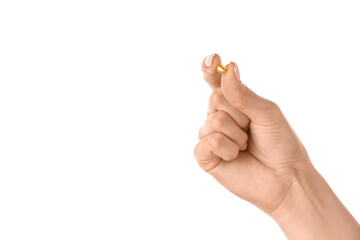 Female hand and pill on white background