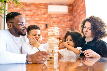 african mixed race family palying a round of jenga in cozy living room with air conditioning