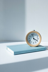 notebook diary and alarm clock on the white background.