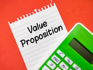 Text Value Proposition writing on notepaper with calculator on a red background.