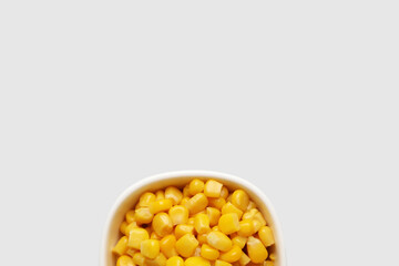 Bowl of corn kernels on white background