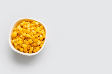 Bowl of corn kernels on white background