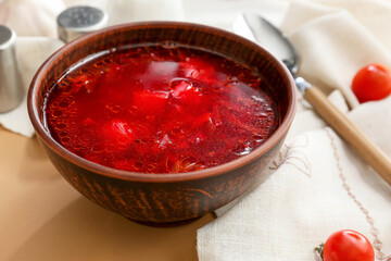 Bowl with tasty borscht on table