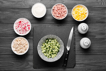 Bowls with different ingredients for okroshka on dark wooden background