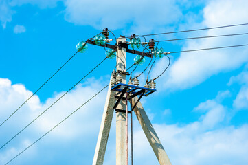 High voltage power lines in summer against the backdrop of white clouds and blue sky. High voltage...