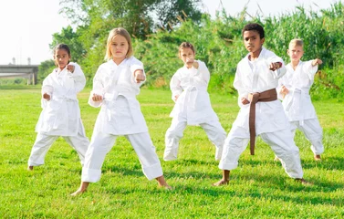 Fotobehang Children exercising in karate and traditional martial arts outdoor © JackF