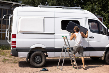 Camper van conversion - Man installing a side window © photoschmidt