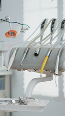 Close-up of dental tooth intruments in medical stomatology orthodontic office in hospital room with nobody in it. Medical workplace with orthodontist chiar prepared for teethcare treatment