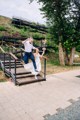 beautiful bride and groom happily jump down the stairs