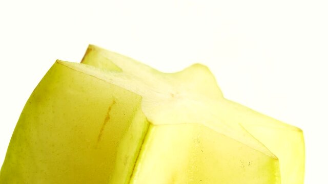 4K Organic star fruit carambola or star apple ( starfruit ) close-up rotates on a white background