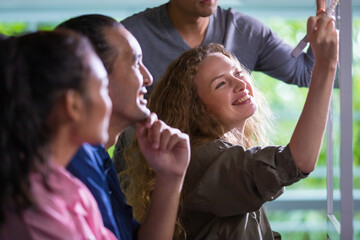 Selective focus on Caucasian casual business woman with doubtful face with bad or negative result of work or performance while looking report on screen of computer together with colleagues in office.