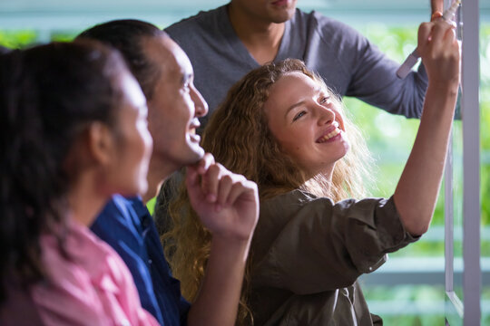 Selective focus on Caucasian casual business woman with doubtful face with bad or negative result of work or performance while looking report on screen of computer together with colleagues in office.