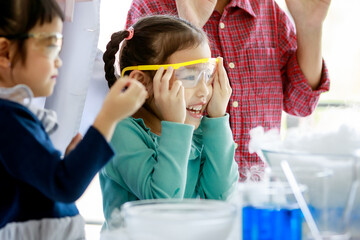 Asian kids happily and curious watching reaction of smoke lab testing in science subject in class...