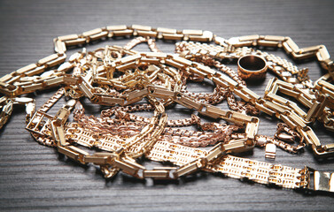 Group of gold jewelry on dark background.